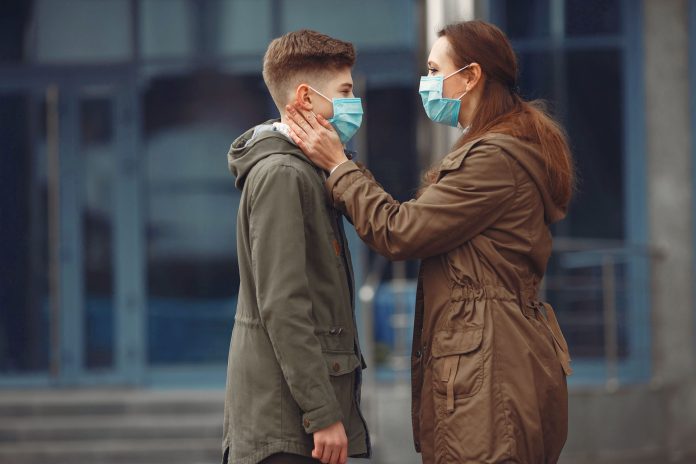 A boy and mother are wearing protective masks